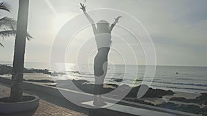 Silhouette yoga practice at sunset. Yong woman doing yoga exercise on the beach