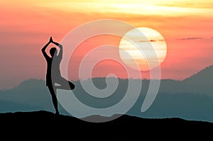 Silhouette Yoga practitioner during twilight sunset meditation with Omega sunset or Inferior-Mirage Sunset