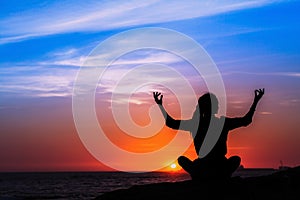 Silhouette of yoga woman alone meditation on the ocean .