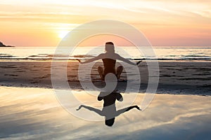 Silhouette yoga woman on the background of the sea and amazing sunset.