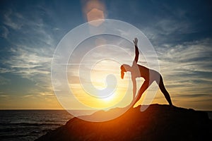 Silhouette of yoga woman doing exercises on the Sea coast