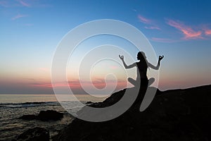Silhouette of yoga woman on the ocean beach