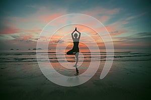 Silhouette yoga woman on the sea at sunset. Fitness and meditation.