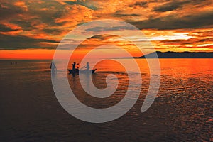 Silhouette of young adults having fun at the beach