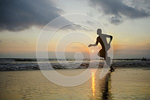 Silhouette of young athletic and fit african american sport man doing running workout on sunset at the beach training hard jogging