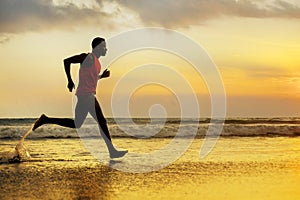 Silhouette of young attractive fit athletic and strong black African American man running at sunset beach training hard and