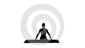 Silhouette young attractive woman practicing yoga, sitting in gomukasana exercise, cow face pose.