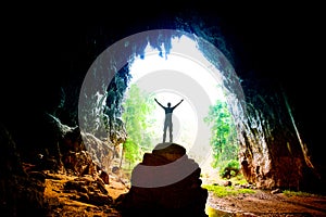 Silhouette young backpacker Man on background giant pavilion cave