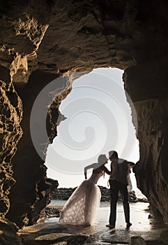 Silhouette of young beautiful bridal couple having fun together at the beach