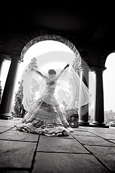Silhouette of young beautiful bride dancing under a pillared roof
