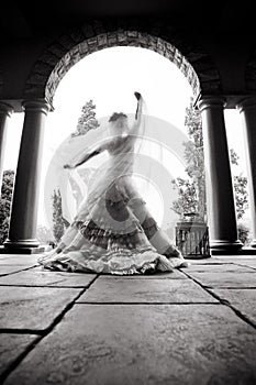 Silhouette of young beautiful bride dancing under a pillared roof