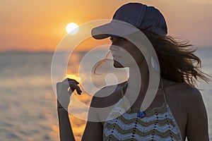 Silhouette of a young beauty girl at tropical beach near sea water at paradise island at sunset. Holiday travel