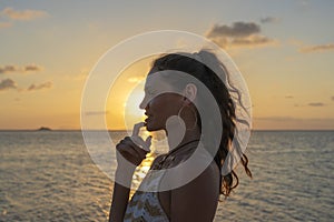 Silhouette of a young beauty girl at tropical beach near sea water at paradise island at sunset. Summer concept. Holiday travel