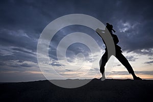 Silhouette of young boy performing a pencak silat