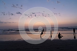 Silhouette of young boy performing stunts in front of sea