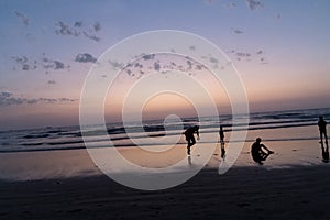 Silhouette of young boy performing stunts in front of sea