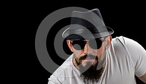 Silhouette of young confident handsome bearded man hipster in ha