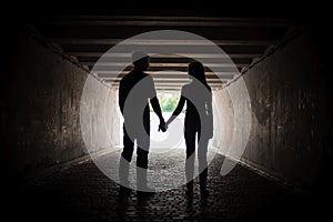 Silhouette of young couple holding hands