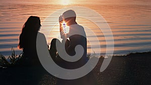 Silhouette of a young couple kissing at the beach