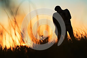 Silhouette of a young couple kissing at sunset