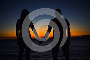 Silhouette of young couple in love at the beach