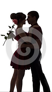 Silhouette of a young couple in love dance on white isolated background, man hugging woman holding rose flower, concept romance