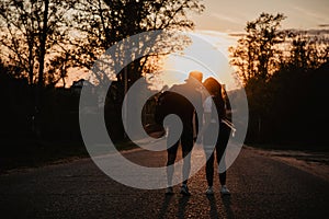 silhouette of a young couple in love kissing at sunset in summer