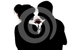 Silhouette of a young couple in love on white isolated background, a man with a rose flower for a woman hugging her behind,