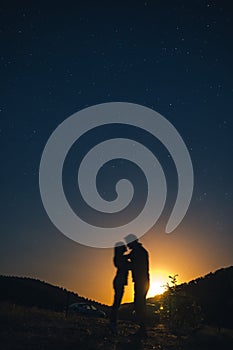 Silhouette of young couple under stars. The concept on the theme of love. romantic evening together, sunset, vertical photo