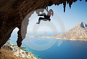 Silhouette of young female rock climber on a cliff