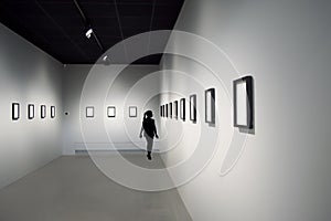 Silhouette of young girl at art exhibition