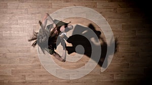 Silhouette of young girl is dancing, spining on wooden floor, shadow, ballet concept, movement concept, top shot