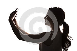 Silhouette of young girl with a smartphone