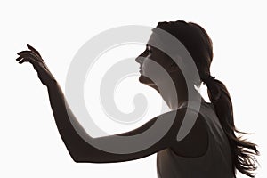 Silhouette of a young girl touching something