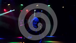 Silhouette of young guy dancing in a nightclub.