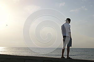 Silhouette of a young guy near the sea