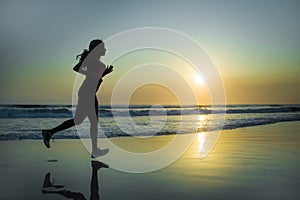 Silhouette of young happy and attractive African American runner woman exercising in running fitness workout at beautiful beach jo
