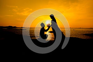 A silhouette of a young man, down on one knee and holding a bouquet, proposing to his girlfriend. will you marry me images.