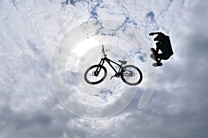 Silhouette of a young man freestyle stunt cyclist flying in the sky performing stunt jump