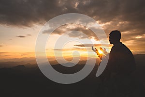 Silhouette of young  man hands open palm up worship and praying to god  at sunrise, Christian Religion concept background