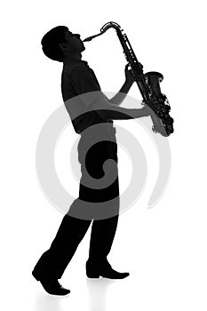 Silhouette of a young man playing a wind instrument on isolated background