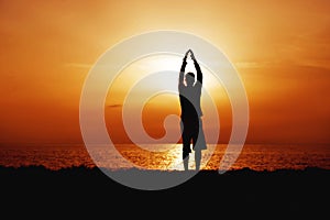 Silhouette of Young Man Practicing Yoga. Sunset on the Seacoast. Back Bend Position, Anuvittasana