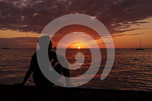 Silhouette of young man reflecting and contemplating nature by the beach during his relaxing and happy vacation