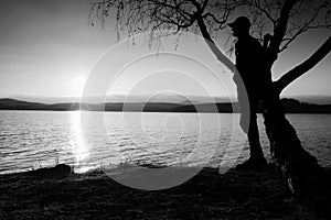 Silhouette of young man stand on beach at sunset. Shadow of active man