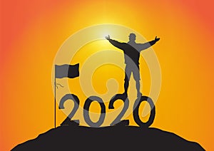 Silhouette of young man standing on top of the mountain on year 2020 with hands up with flag on sunrise background