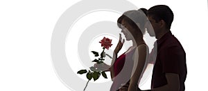 Silhouette of a young man and woman in love on white isolated background, boy came up behind to girl to make a surprise with rose