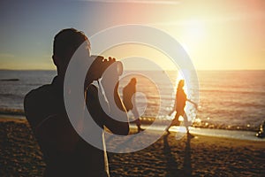 Silhouette of young photographer on the beach