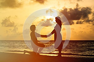 Silhouette of a young romantic couple at sunset beach