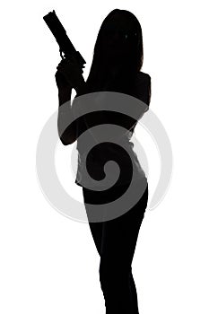 Silhouette of young spy woman with gun