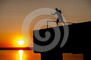 Silhouette of Young Strong Male Boxer Working Out On The Pier